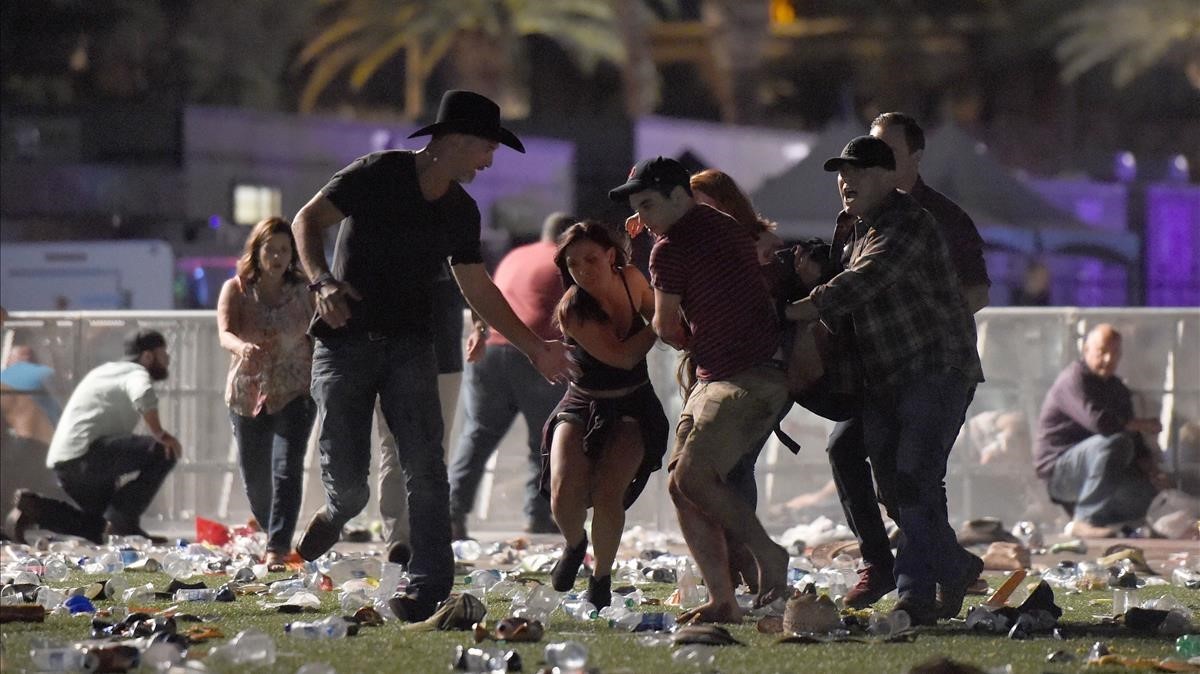 Asistentes al concierto en Las Vegas socorren a uno de los heridos.