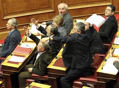 El líder de los comunistas griegos, Girogos Mavrikos, lanza el borrador del acuerdo en plena sesion del Parlamento.