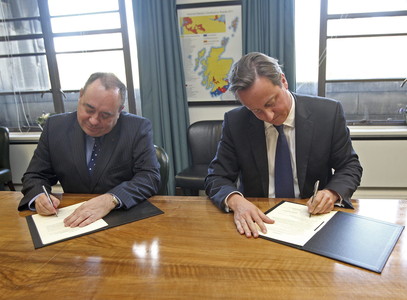 El primer ministro británico, David Cameron (derecha), y el nacionalista Alex Salmond firman el acuerdo sobre el referendo de independencia escocesa