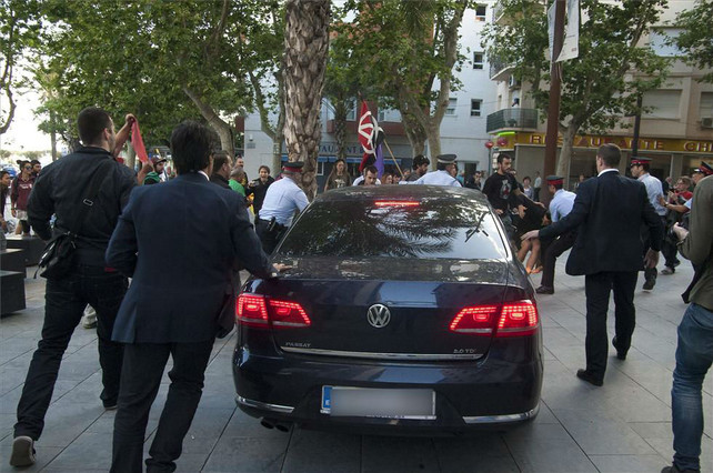 Guardaespaldas y manifestantes siguen al coche de Montoro, en Vilanova i la Geltrú.