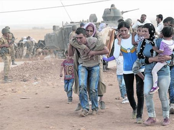 Refugiats kurds sirians travessen la frontera i entren a Turquia, dissabte.