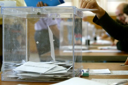 Un ciudadano deposita su voto en una urna. 