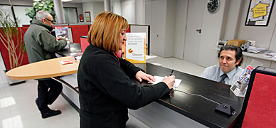 Una clienta realiza una gestión en una oficina bancaria en tona (Osona)