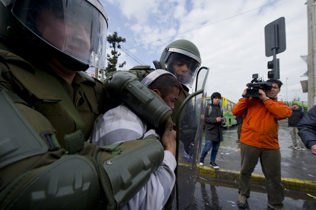 Dos policías arrestan a uno de los manifestantes durante la huelga convocada por la CUT en Santiago de Chile. MARTIN BERNETTI | AFP