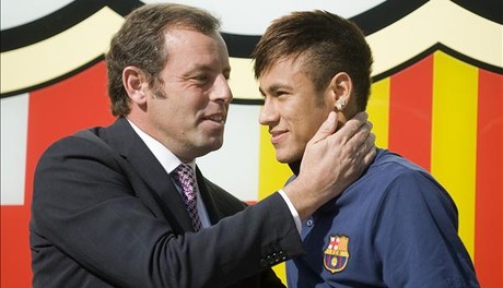 Rosell y Neymar posan ante el escudo del Barça en las oficinas del club el día de la presentación del jugador.