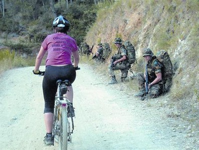 Una ciclista pasa junto a los soldados del Bruc mientras pedalea, el 12 de septiembre, por Collserola.