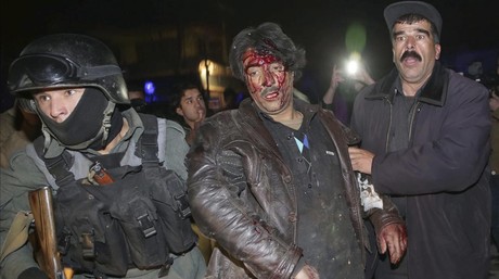 Dos policías trasladan a un herido tras el ataque suicida en Kabul, este viernes.