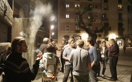 Clients d'un bar de la zona del Born, a Barcelona, aprofiten el descans del partit Reial Madrid-Barça de dimecres passat per sortir a fumar un cigarret a les portes del local.
