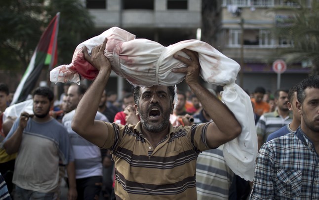 Un hombre sostiene el cadáver de un niño fallecido en el ataque en una escuela de la ONU, este viernes en Beit Lahia.