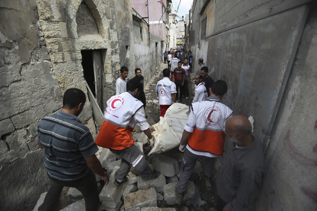 Médicos palestinos evacúan un cadáver en el barrio de Shayahía, este domingo.