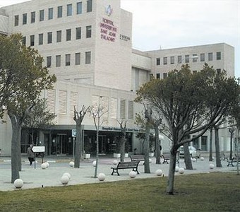 El Hospital de SanJuan de Alicante y, a la derecha, un sanitario protegido durante el ingreso de ayer.