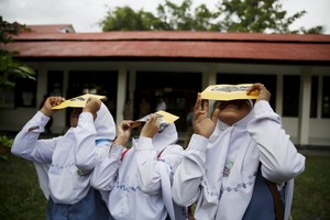 Students test their self-made filters and look at the sun after a joint workshop between the Hong Kong Astronomical Society and Indonesia's National Institute of Aeronautics and Space (LAPAN) at a high school in Ternate island, Indonesia, ahead of Wednesday's solar eclipse, March 7, 2016. REUTERS/Beawiharta