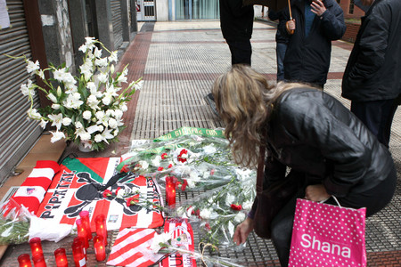 Una mujer deposita unas flores en el lugar en el que el joven Iñigo Cabacas falleció.