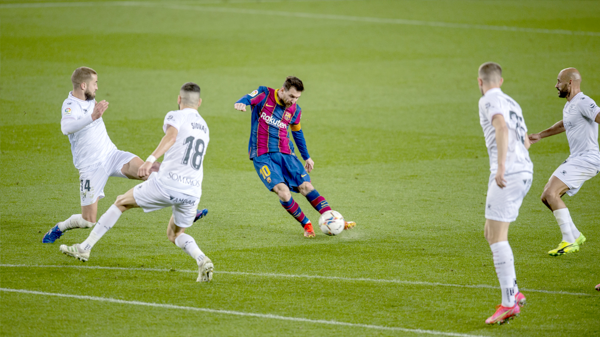 Leo Messi dispara desde fuera del área rodeado de jugadores de la SD Huesca.