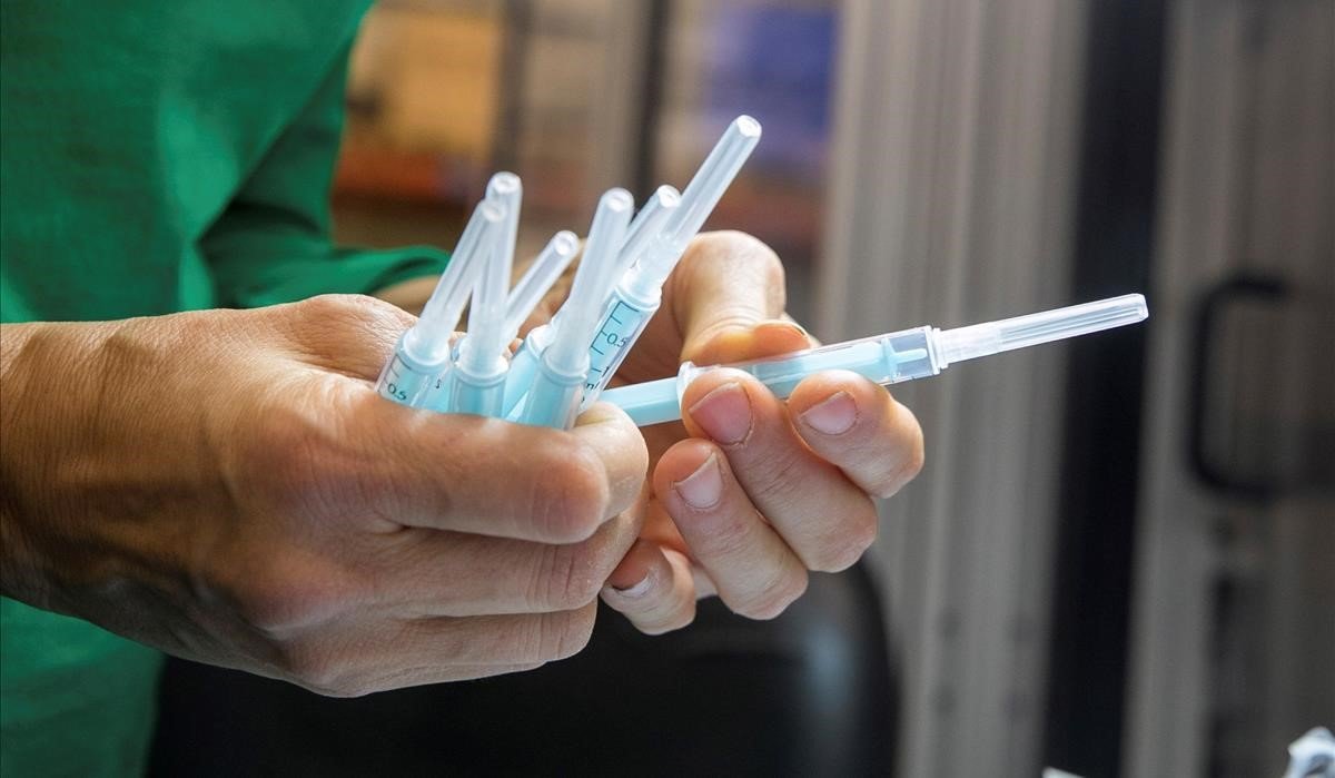 Una operaria inspecciona muestras de jeringuilla para la vacuna contra el coronavirus. 