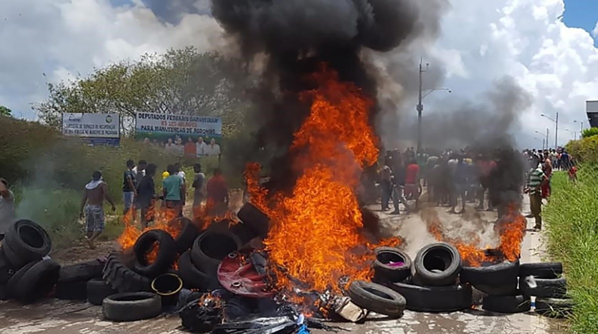 Habitantes de la ciudad brasileña de Pacaraima, en la frontera con Venezuela, incendian neumáticos y pertenencias de inmigrantes venezolanos durante los disturbios registrados el 18 de agosto del 2018.