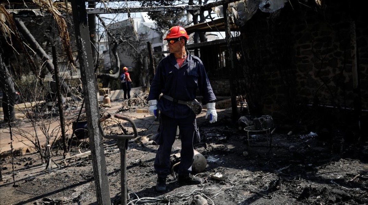Un bombero inspecciona una de las viviendas quemadas por las llamas en la ciudad de Mati, prÃ³xima a Atenas.&#160;