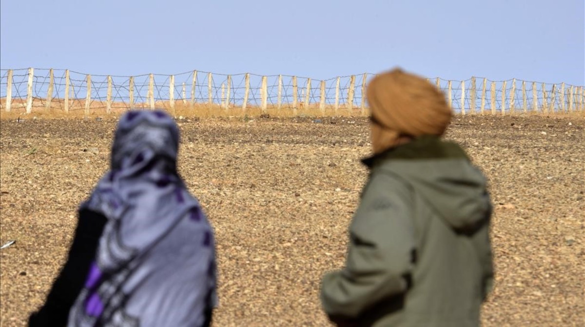 Zghala, una mujer del SÃ¡hara Occidental, mira hacia la valla en el Ã¡rea de Al-Mahbes, mientras acompaÃ±a a su hijo de 14 aÃ±os para mostrarle el muro que separa Marruecos de la zona controlada por el Polisario, el 3 de febrero del 2017.
