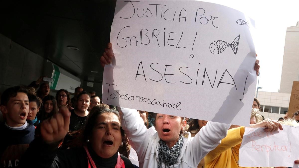 Un centenar de personas gritan pidiendo justicia al paso del furgon policial en Almería, ayer.