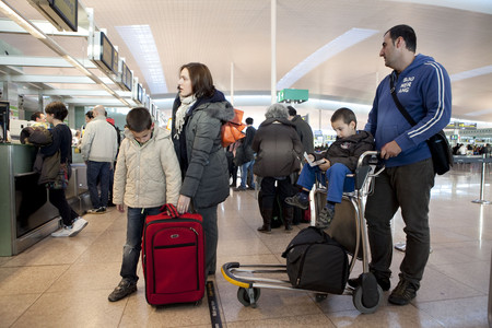Una familia, el pasado viernes, en El Prat, antes de partir hacia Granada.