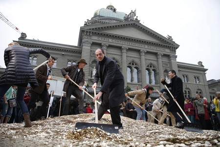 Activistas colocan cntimos en el suelo a las puertas del Parlamento en Berna, el pasado da 4.