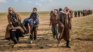 Presuntos militantes del Estado Islámico llevan en brazos a un herido, en la provincia siria de Deir Ezor