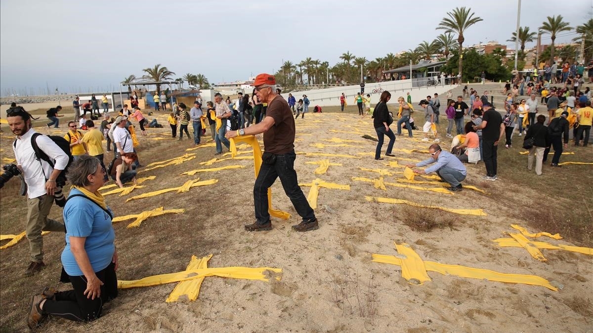 La plantada de cruces en la playa de MatarÃƒÂ³ se hace con telas amarillas