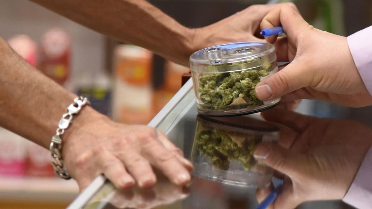 Un hombre vende a otro cogollos de cannabis en una tienda de California (EEUU), el pasado 1 de enero.