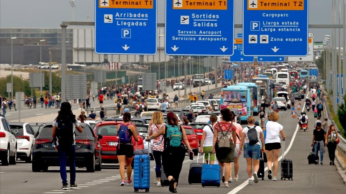 Varios viajeros cerca del aeropuerto de El Prat, afectados por las protestas convocadas por Tsunami Democràtic tras la sentencia del juicio del ’procés’.